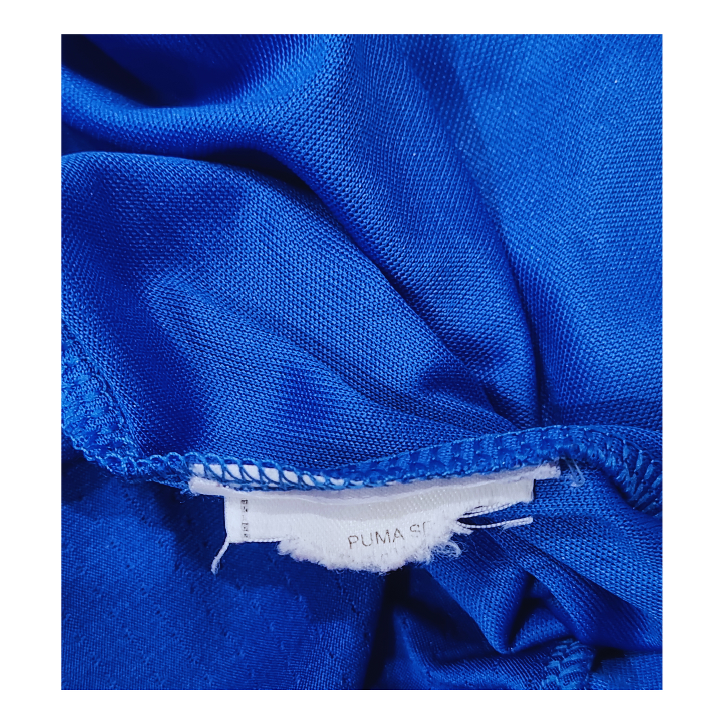 A close up of a vintage blue fabric with a Puma label on Italy 2014 Home Jersey.