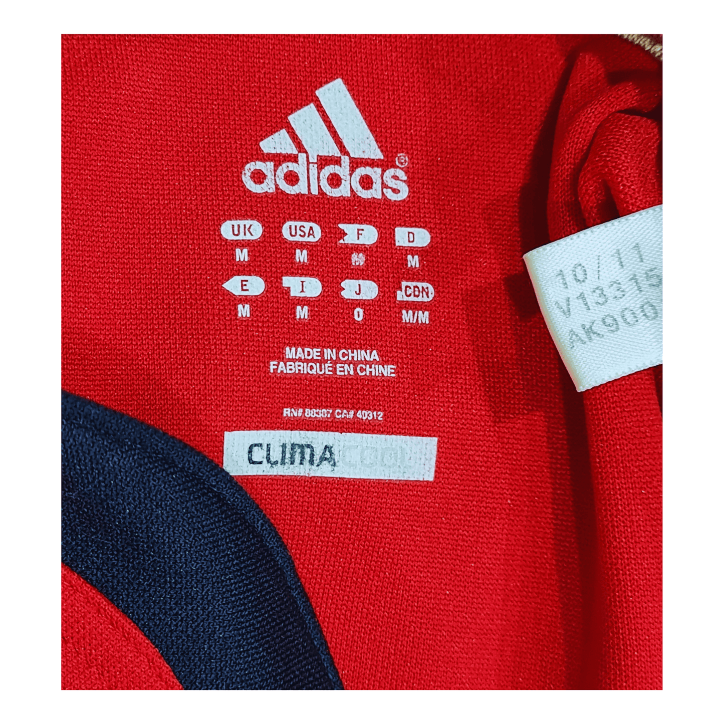 A red Adidas Munster 2011/12 Home Jersey with a label on it.
